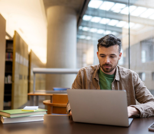 Photo homme révise ou étudie à la bibliothèque préparation examen concours révision