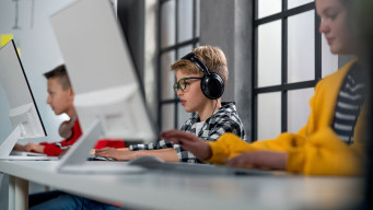 Photo élèves collégiens devant ordinateur avec un casque sur les oreilles laboratoire de langues informatique collège 